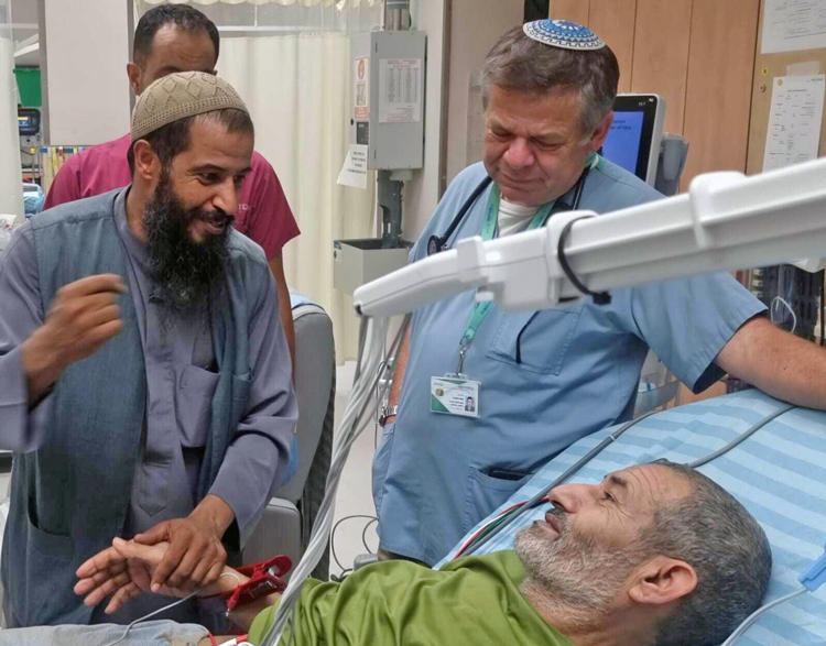 Rehén Farhan al-Qadi, un beduino ciudadano israelí, con un pariente y un médico después de ser rescatado por soldados israelíes. Matones de Hamás le dispararon cuando se rehusó a llevarlos donde estaban los judíos. “Musulmanes, judíos, beduinos, una familia, un pueblo”, dijo.