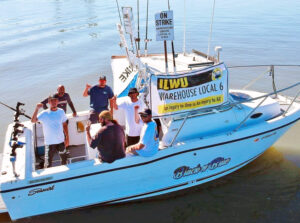 Yousaf Pasha, standing on right, and fellow ILWU members who were on strike against Georgia-Pacific in Antioch, California, used their fishing boat to discourage delivery ship crew from bringing supplies to company. When ship’s crew saw the signs, they turned ship around.