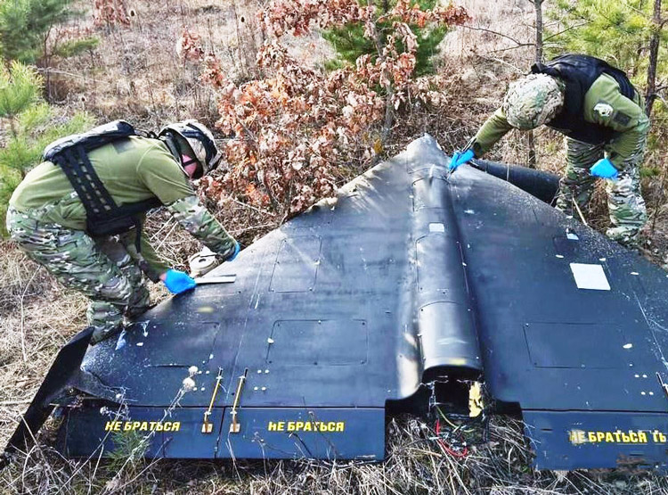 Ukrainian troops inspect crashed Iranian-made drone. Moscow has targeted Ukraine with 8,000 drones since 2022. Even with 90% shot down, thousands of civilian casualties resulted.