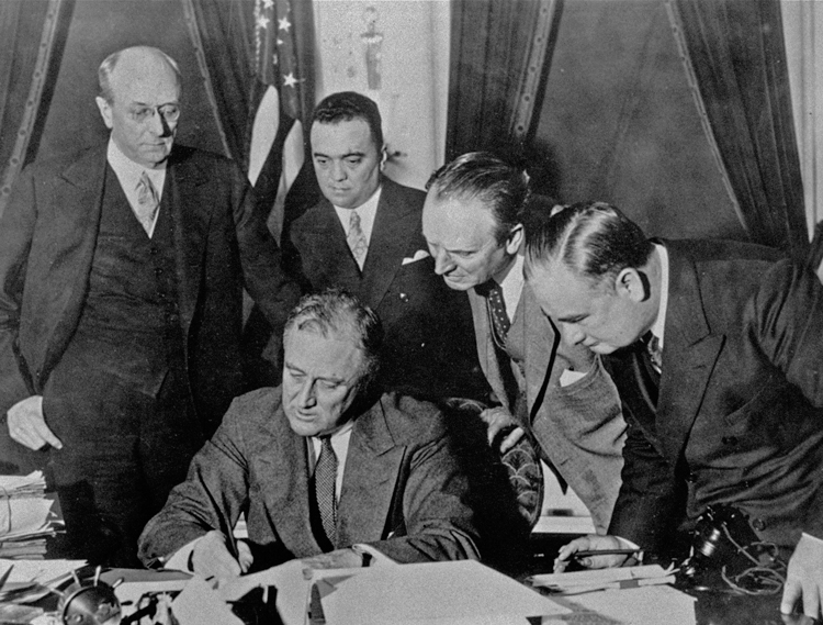 FBI Director J. Edgar Hoover, second from left, watches President Franklin Roosevelt sign 1934 bill expanding federal bureau’s powers. As U.S. rulers prepared to enter imperialist competition for markets and power in World War II, they used FBI to frame up union fighters and SWP.