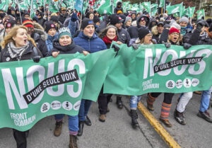 Unionists march behind banner reading “The Common Front: United with a single voice” in Montreal December 2023. Today workers are fighting new attacks on unions, right to strike.