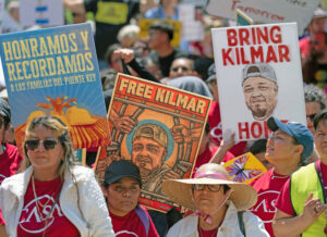 Demonstrators at White House May 1 demand Kilmar Abrego García and other detained immigrant workers be freed. Placard on left says, “We honor and remember the Key Bridge families” of six immigrant workers killed when Baltimore bridge collapsed last year.