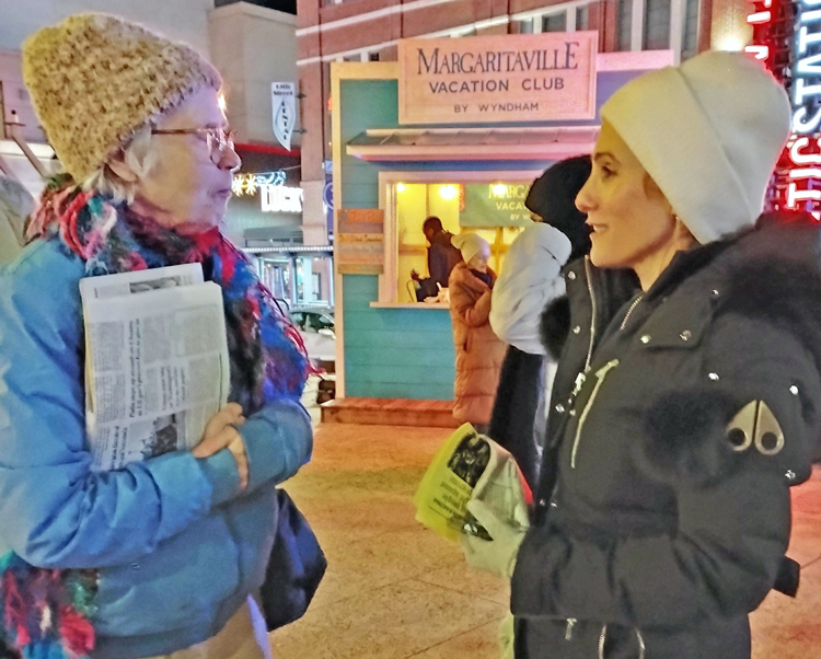 SWP member Marklyn Wilson, left, shows ,<i>Militant</i> and discusses party’s condemnation of Jew-hating massacre in Australia with Dena Schusterman at Dec. 15 Atlanta Hanukkah celebration.