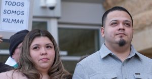 Kilmar Ábrego García, freed from detention by widespread support, and his wife, Jennifer Vasquez Sura, leave court in Greenbelt, Maryland, Dec. 22. The sign says, “We are all Kilmar.”
