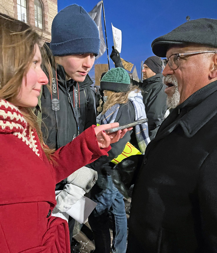 John Hawkins, right, SWP candidate for U.S. Senate in Ohio, talks to reporters at Jan. 23 protest in Cincinnati.