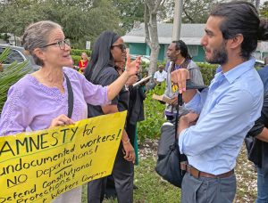 Socialist Workers Party member Laura Anderson discusses how fight for amnesty can unite the working class, strengthen unions with Daniel Subdiaz at Jan. 12 protest by Haitians in Miami.