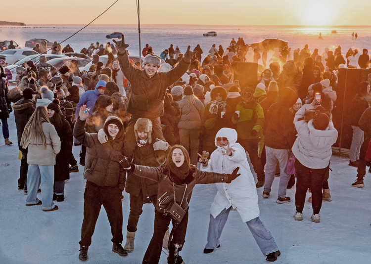 People dance at sunset on frozen Kyiv Sea reservoir on Dnipro River in Ukraine Feb. 1. Working people refuse to be intimidated despite Moscow’s airstrikes on country’s electrical infrastructure causing widespread power and heating outages in middle of the winter.