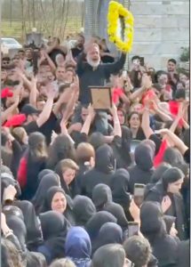 Father of 18-year-old Mani Safarpour holds up his son’s picture during 40-day commemoration in Tehran. Participants sang, danced and cheered. Safarpour was murdered Jan. 8 when he tried to rescue a young woman being fired on by regime’s thugs at a protest.