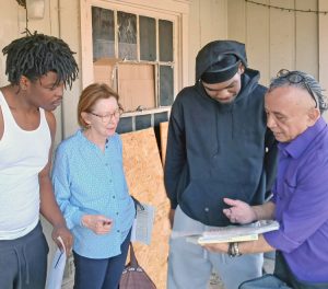 Alyson Kennedy, SWP candidate for governor of Texas, and party member Gerardo Sánchez, right, speak with FedEx facility workers Jamarion Conner, left, and Caleb Carter while campaigning against U.S. attacks on Iran door to door in Fort Worth March 1.