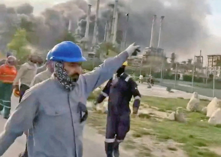 Workers flee after Iranian drones hit the Ras Tanura refinery, one of the world’s largest, in Saudi Arabia March 2. Iran has carried out bombing and drone attacks in Israel as well as in Saudi Arabia, the United Arab Emirates, Qatar, Kuwait, Bahrain, Oman, Jordan and Iraq. 