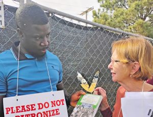 Alyson Kennedy, SWP candidate for governor in Texas, shows Cuba and the Independence War in Guinea-Bissau and Cape Verde to Jacquelin Prevarice, a JBS striker in Greeley March 24.