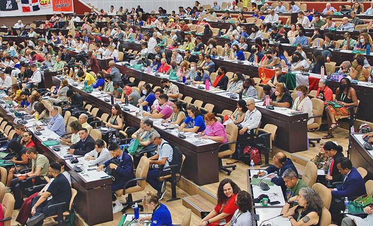 Top, René González Barrios, director of Fidel Castro Ruz Center, opens First International Fidel Colloquium: Legacy and Future, in Havana Aug. 10. On far right of panel is Cuban President Miguel Díaz-Canel. Below, part of audience of 1,500 participating in event.