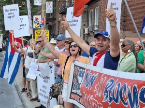 Protest in defense of Cuba outside Cuban Consulate in Montreal, one of several across world July 26, demands end of U.S. economic blockade. Sign top left says, “Honk to show support.”