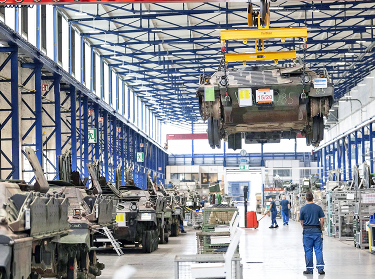 Berlin is sharply expanding militarization, including converting car plants to arms production. Above, production line at Rheinmetall tank factory, the largest in Europe, in Kassel, Germany.